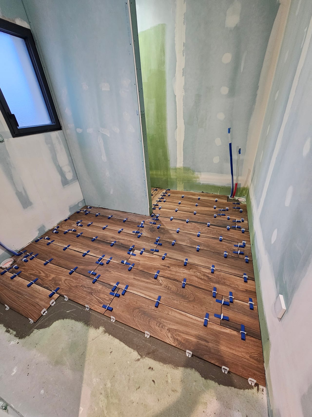 Carreaux effet bois, cales de nivellement et parois en préparation